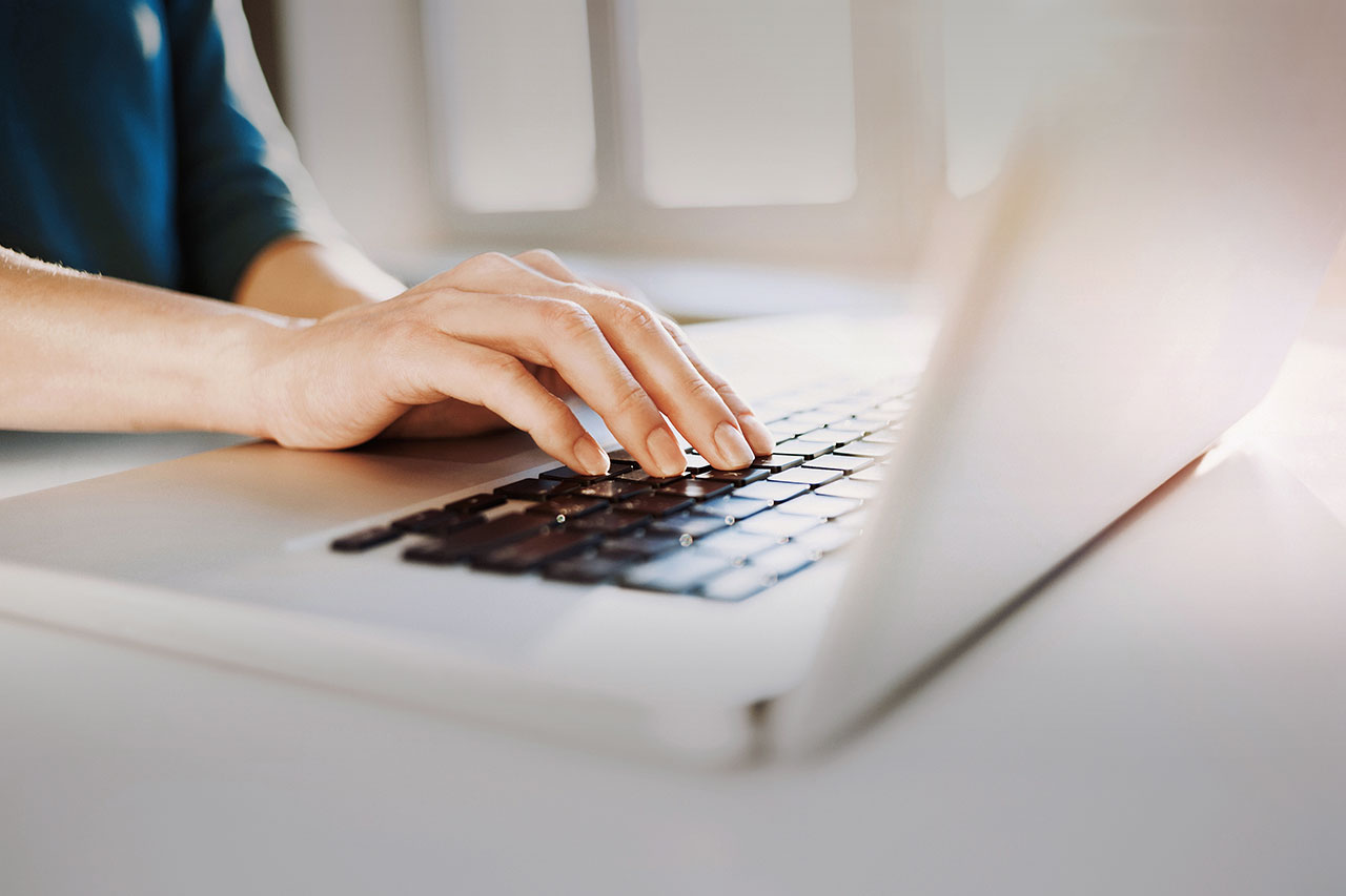 image of hand hovering over laptop keyboard